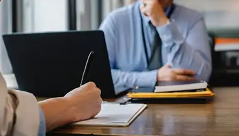 Office worker is interviewed while the another takes notes